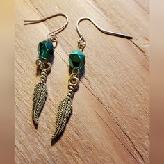 2⅝ Inch Long Gold Tone Metal Feather Charm Earrings. These Beautiful Earrings Are Hand Crafted On Gold Tone Metal Findings With A Green Glass Bead. $10.00+S&H #Countrygypsyor Metal Feather, Gem Drop Earrings, Marcasite Earrings, Turquoise Earrings Dangle, Chanel Earrings, Heart Dangle Earrings, Feather Charms, Cz Stud Earrings, Triangle Earrings