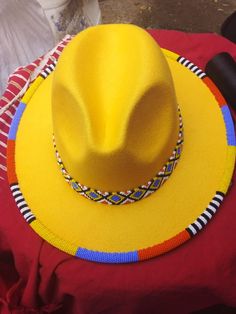 This is a spectacular Yellow rim beaded unisex high quality fedora hat that are hand beaded on the BRIM . It makes one stand out in occassions such trips ,weddings ,birthdays . We use very stunning beads and the craftmanship is very unique Head circumference can fit a size: 57/58cm Yellow Bohemian Fedora Straw Hat, Multicolor Beaded Hat With Curved Brim, Handmade Yellow Hat For Festivals, Multicolor Beaded Brimmed Hat, Handmade Yellow Festival Hat, Beaded Fedora Straw Hat For Rodeo, Beaded Fedora Sun Hat For Rodeo, Bohemian Beach Hats With Bead Caps, Traditional Beaded Rodeo Hats