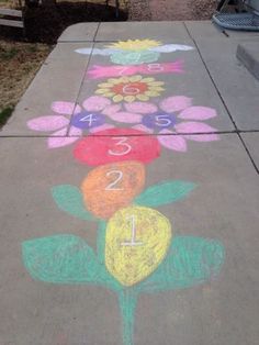 a sidewalk with flowers drawn on it and numbers painted on the pavement next to each other