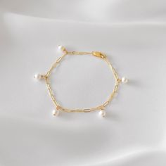 "A dainty link chain bracelet featuring 5 pearl dangles. Pearls are genuine freshwater pearls in a slightly off-round shape. Be sure to measure your wrist if you are going for a tight fit like the model who is wearing the 5.75 inches. Otherwise, the standard length at department stores for women's bracelets is 7 inches. This item is 14k gold filled and is tarnish-resistant, water-resistant, and hypoallergenic. --------------------♥ PROMOS ♥-------------------- Want 10% off? Join the mailing list