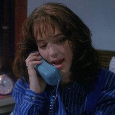 a woman talking on a phone while sitting in bed