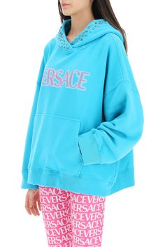 Loop-back cotton jersey sweatshirt by Versace with contrasting lettering logo in a spray effect and studded hood. Kangaroo pocket, ribbed trims and oversized fit. The model is 177 cm tall and wears size 38. Size Info IT Color Detail Light blue Made In Portogallo Material 100% CO Season One spring Season Two summer Product clothing Brand Versace Size And Fit Oversized Hoodie Sweatshirt With Logo Detail, Versace Hoodie, Trench Dress, Jersey Sweatshirt, Workout Sweatshirt, Knitwear Cardigan, Pant Shirt, Spring Season, Roberto Cavalli