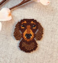 a beaded dachshund is sitting next to some flowers