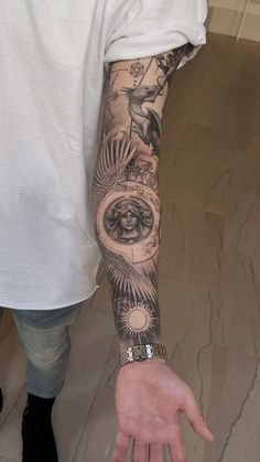 a man with a tattoo on his arm and hand is holding the clock in front of him