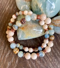 "These beautiful bracelets promote tranquility, yet are grounding. Both are made with Argentinian Lemurian Aquatine Calcite (aka Blue Onyx) and White Fossil Jasper stone beads. One is made with 6mm beads, the other with 8mm beads. The blue green banded calcite beads have different patterns throughout with a brown matrix, making them a perfect fit with the off-white fossil jasper beads and copper accents. Choose your bracelet, with either 6mm or 8mm beads. Together, they make a lovely stack, but Elegant Blue Amazonite Beaded Bracelets, Blue Amazonite Gemstone Beaded Bracelets, Aquamarine Gemstone Beaded Bracelets, Blue Aquamarine Beaded Bracelet With Natural Stones, Blue Aquamarine Beaded Bracelets, Spiritual Style, Handmade Jewlery, Blue Onyx, Trendy Bracelets, 8mm Beads