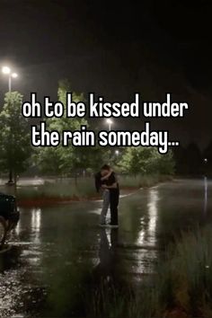 a man and woman kissing in the rain at night with text that reads oh to be kissed under the rain somebody