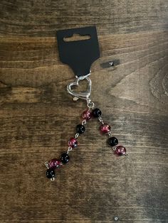 a black and red beaded keychain on a wooden table