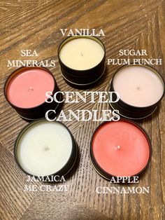 four different types of scented candles on top of a wooden table with words describing them