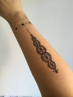 a woman's arm with a tattoo design on the left side of her arm