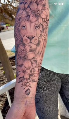 a woman's arm with a lion and flowers on it