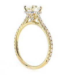 a yellow gold engagement ring with an oval center stone and side stones on the band