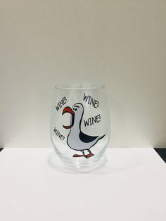 a wine glass sitting on top of a white table next to a black and white wall