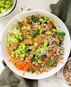 a white bowl filled with rice, peas and carrots on top of a table