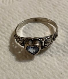 This little ring is so tiny and delicate that my camera couldn't capture all the detail. I believe it is Native American made.  It is marked 925 inside. It fits my pinky perfectly so it should measure in as a size 6. I got this ring in an estate group of jewelry. I can only guess at its age.  It belonged to a woman about 80 years of age so she may have owned it since maybe the 1960's-80's somewhere.  Free shipping in the US. Sterling Silver Heart Crystal Promise Ring, Silver Heart Cut Ring With Birthstone, Vintage Heart Cut Birthstone Ring, Vintage Heart Cut Birthstone Heart Ring, Silver Heart Birthstone Ring For Promise, Dainty Silver Topaz Promise Ring, Vintage Sterling Silver Topaz Promise Ring, Vintage Silver Heart Ring For Promise, Vintage Silver Topaz Birthstone Ring