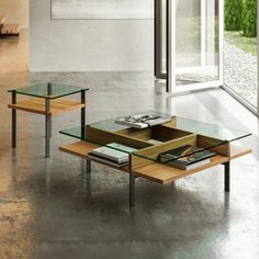 two tables with glass tops in an empty room