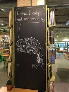 a chalkboard with a drawing of a t - rex on it in a library