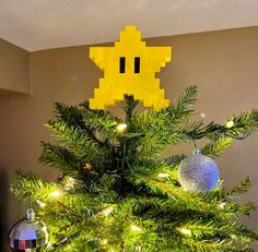 a yellow pacman ornament on top of a christmas tree