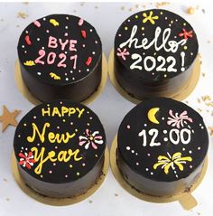 four black and gold decorated birthday cakes sitting on top of a table