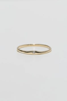 a gold ring with a single diamond on the top and bottom, against a white background