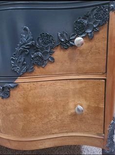 an old dresser has been painted with black paint and flowers on it's drawers