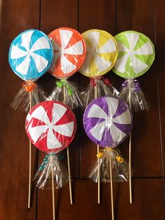 lollipops wrapped in cellophane and tied to wooden sticks on a table