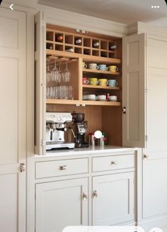 a kitchen with white cabinets and glassware