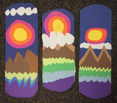 three skateboards decorated with mountains and clouds