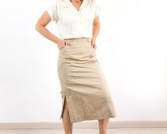 Amazing vintage high waist midi pencil skirt in tan beige. This vintage minimalist midi skirt has waist with belt loops and back button and zip closure, side splits and pockets. The 80's wiggle pencil skirt is cotton and polyester fabric with inner lining in excellent vintage conditions by Mode Weiss. The size skirt is Small, the waist contour fit is 25,1 inches (64 cm). ** MEASURES FLAT ** Waist 12,5 in // 32 cm Hip 19,3 in // 49 cm Length 30,7 in // 78 cm Reference: Model size S (4 US - height Summer Fitted Beige Pencil Skirt, Fitted Beige Pencil Skirt For Summer, Summer Office Pencil Midi Skirt, Summer Office Midi Pencil Skirt, Cream Pencil Skirt For Workwear, Summer Midi Pencil Skirt For Office, Summer Office Beige Pencil Skirt, Beige Pencil Skirt For Summer Office Wear, Beige Office Skirt For Summer