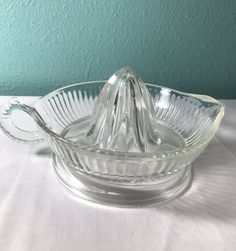 a glass bowl with a handle sitting on a table