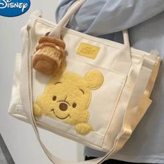 a person holding a winnie the pooh bag