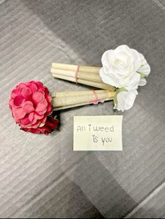 two fake flowers are sitting next to a note that says, all i need is you