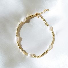 "Our Saylor Pearl Bracelet is absolutely eye-catching! What do we love about it? The stunning gold beads mixed with the natural pearls make for a beautiful piece to stack with your other bracelets. --------------------- FEATURES ◊ Genuine baroque freshwater pearl (5-6mm x 7mm) ◊ Yellow Gold, Rose Gold or Silver Plated Hex Spacer Beads ◊ 100% Gold-filled or Sterling Silver extender chain and findings (clasp/jump rings) to ensure the highest quality piece ◊ We include a 1\" extender to add 1\" of Handmade Adjustable Rondelle Pearl Bracelet, Adjustable Beaded Pearl Charm Bracelet, Adjustable Pearl Bracelets With Round Beads, Pearl Bracelets With Gold Round Beads, Dainty Pearl Beaded Bracelets With Spacer Beads, Dainty Pearl Beaded Bracelet With Spacer Beads, Gold Beads Pearl Bracelets, Adjustable Dainty Pearl Bracelet With Faceted Beads, Pearl Bracelets With Gold Beads As A Gift