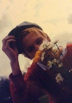 a woman is holding flowers and talking on the phone