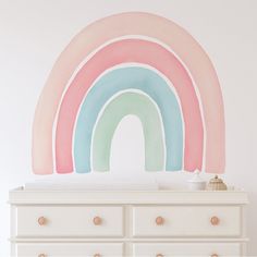 a white dresser with a rainbow painted on it