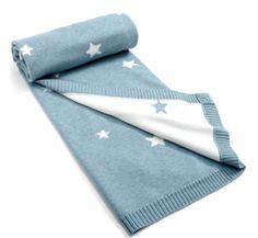 a blue blanket with white stars on it and a folded towel laying next to it