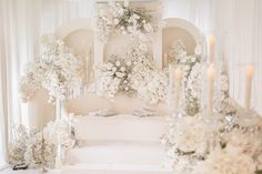 a white wedding cake with flowers and candles