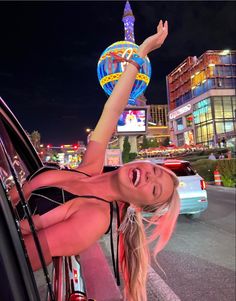 a woman riding on the back of a car