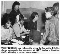 a group of people sitting at a table with papers and pens in front of them