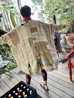 a woman standing on top of a wooden deck next to a table filled with bottles