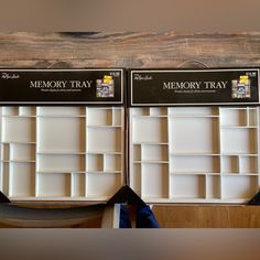 two empty memory trays sitting on top of a wooden table next to each other