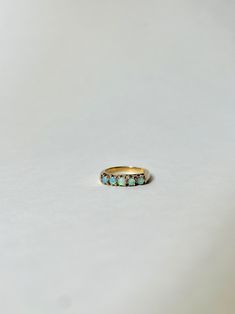 Vintage 14k Gold and Australian Opal Band Ring. This vintage band ring is made with 14k gold and contains 5 cabochon Opals. Marked 14k, S inside of a Diamond. Most likely made between the 1920's-1940's. SIZE: 6 3/4 OVERALL CONDITION: Minor scuffs on the band but overall beautiful condition. GEMSTONES: 5 Australian Opals Vintage Multi-stone Opal Ring For Formal Occasions, Classic Yellow Gold Turquoise Ring, Heirloom Yellow Gold Emerald Cabochon Ring, Classic Multi-stone Oval Cabochon Rings, Vintage Yellow Gold Oval Turquoise Ring, Antique Turquoise Ring In Yellow Gold, Classic Cabochon Turquoise Ring In Yellow Gold, Vintage Yellow Gold Turquoise Oval Ring, Classic Yellow Gold Turquoise Cabochon Ring