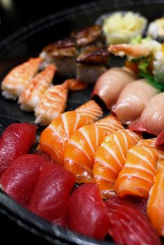 there are many different types of sushi on the plate, including salmon and shrimp