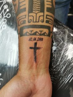 a person with a cross tattoo on their arm