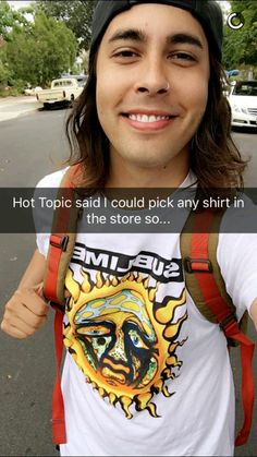 a man with long hair wearing a hat and suspenders is smiling at the camera