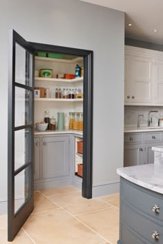 a kitchen with gray cabinets and marble counter tops