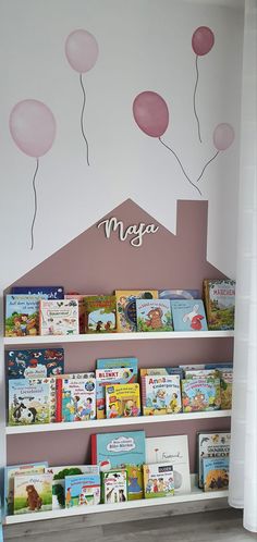 the children's bookshelf has pink balloons on it and is decorated with white walls