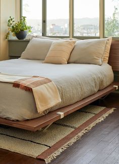 a bed sitting on top of a wooden platform in front of a window with the words made for keeping