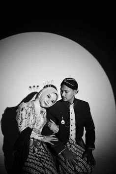 black and white photo of a man and woman dressed in traditional garb sitting together