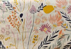 an orange, yellow and pink floral print on white fabric with small flowers in the background