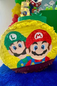 a paper plate with mario and luigi on it sitting on top of a blue rug